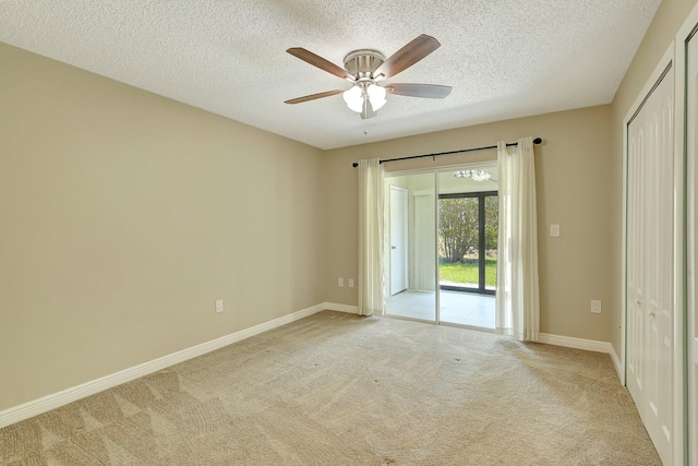 carpeted spare room featuring ceiling fan and a textured ceiling