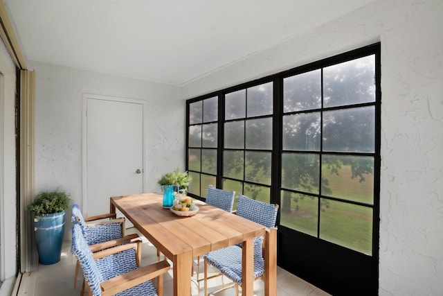 tiled dining room featuring a healthy amount of sunlight