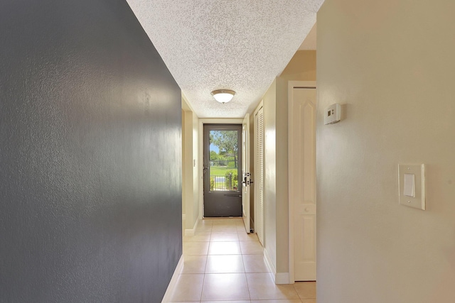 corridor with light tile patterned floors and a textured ceiling