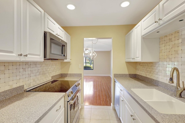 kitchen featuring white cabinetry, stainless steel appliances, sink, and backsplash