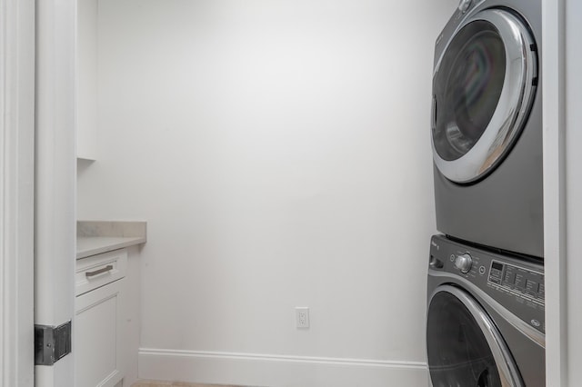 clothes washing area with stacked washer / dryer