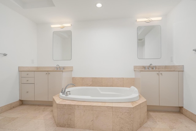 bathroom with vanity and tiled bath