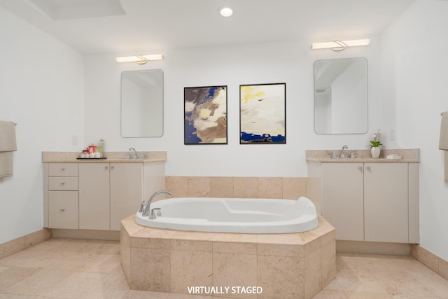 bathroom featuring tile patterned flooring, vanity, and a relaxing tiled tub