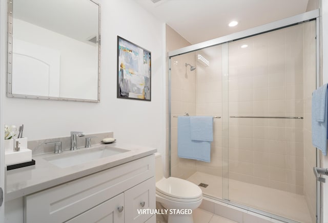 bathroom with tile patterned floors, vanity, toilet, and a shower with shower door