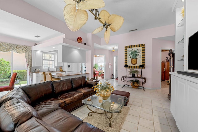 tiled living room with ceiling fan and sink