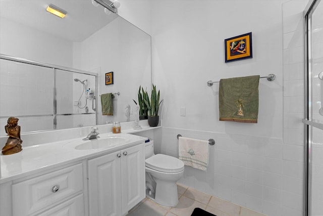 bathroom featuring an enclosed shower, vanity, tile walls, tile patterned flooring, and toilet