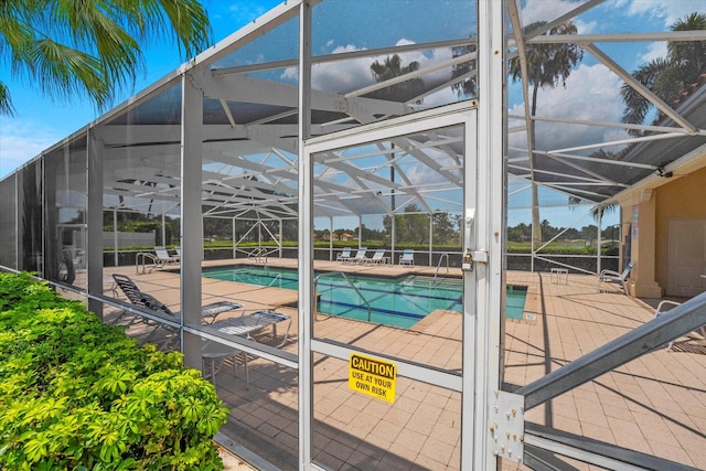 view of swimming pool with a patio and a lanai