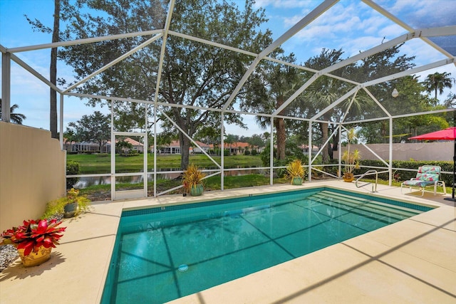 view of swimming pool with a patio, a water view, and a lanai