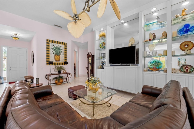 living room featuring ceiling fan, built in features, and light tile patterned floors