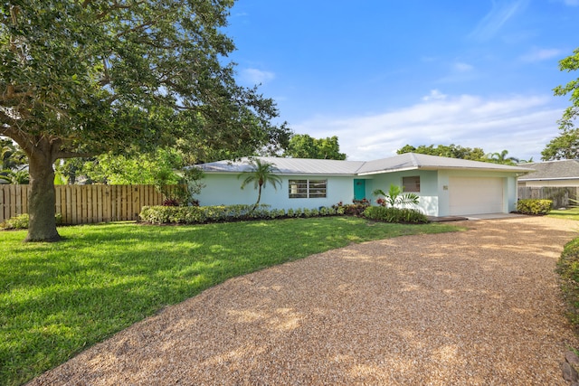 single story home with a front yard and a garage