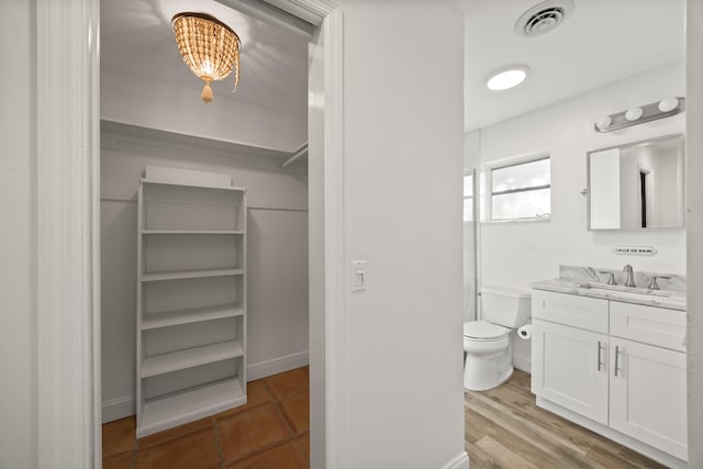 bathroom featuring vanity, hardwood / wood-style flooring, and toilet