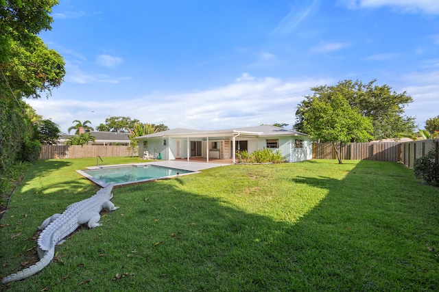 back of house featuring a lawn, a patio area, and a fenced in pool