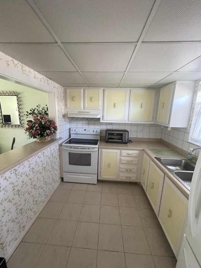 kitchen with light tile patterned floors, sink, decorative backsplash, and white range with electric stovetop