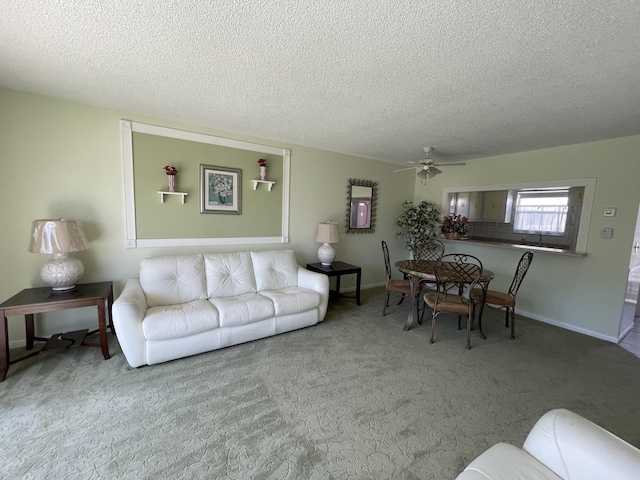 carpeted living room with a textured ceiling and ceiling fan