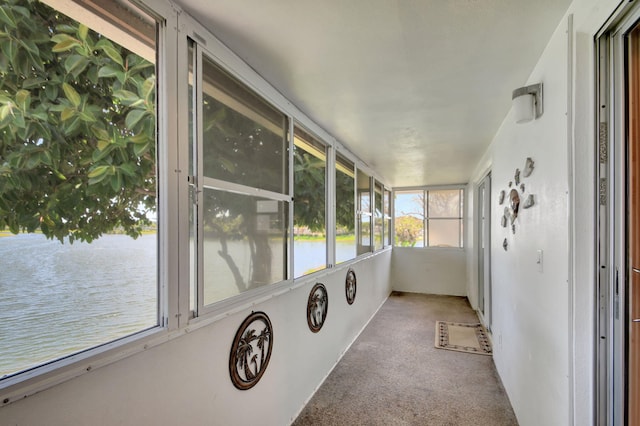 unfurnished sunroom featuring a water view