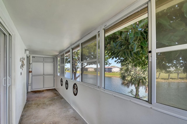 unfurnished sunroom featuring a water view