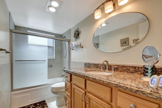 full bathroom featuring tile patterned flooring, vanity, toilet, and enclosed tub / shower combo