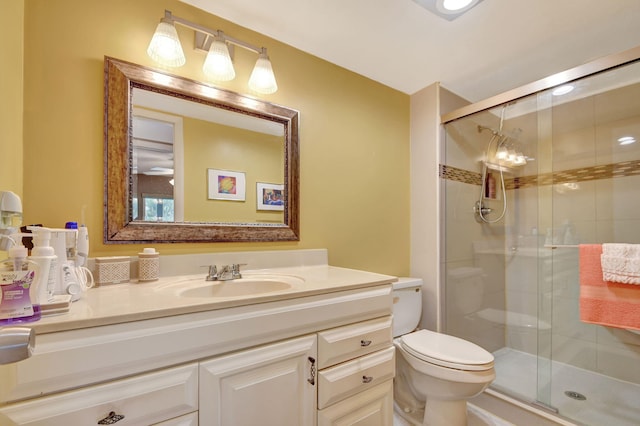 bathroom featuring vanity, an enclosed shower, and toilet