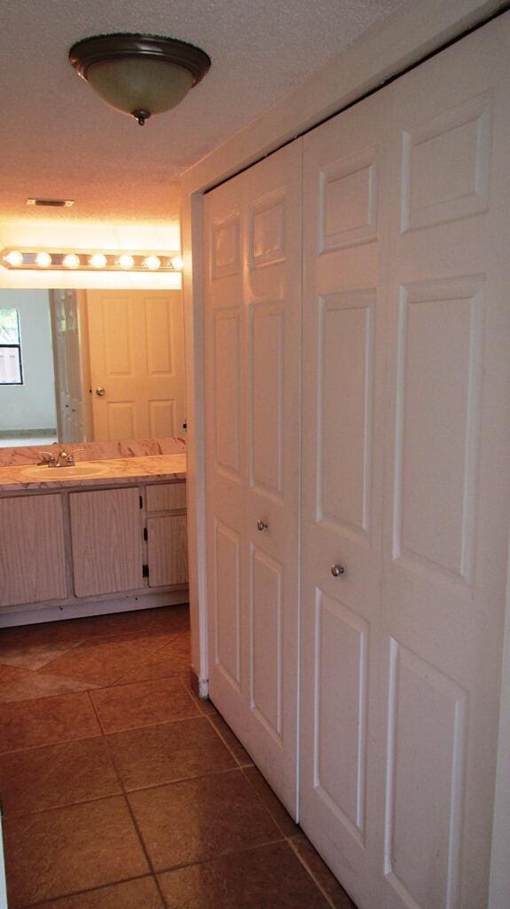 bathroom with tile patterned floors, vanity, and a textured ceiling