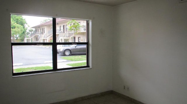 empty room with plenty of natural light and tile patterned flooring