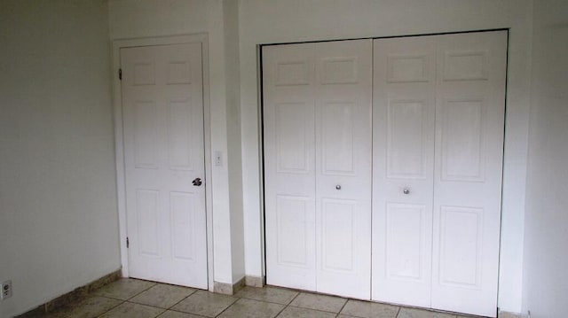 interior space with light tile patterned floors and a closet