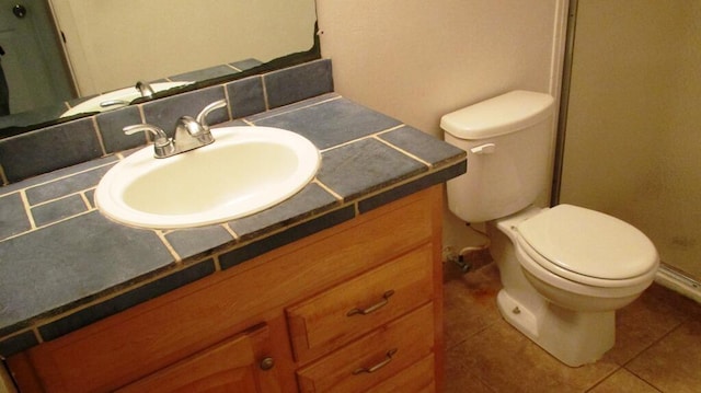 bathroom with tile patterned flooring, vanity, and toilet