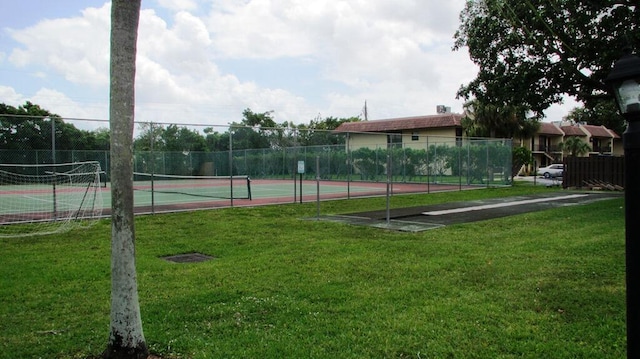 view of sport court with a yard