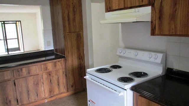 kitchen featuring backsplash, white range with electric cooktop, and tile patterned floors