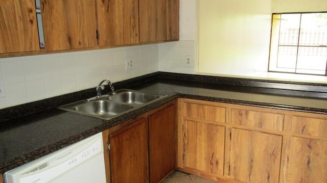 kitchen featuring decorative backsplash, sink, and white dishwasher