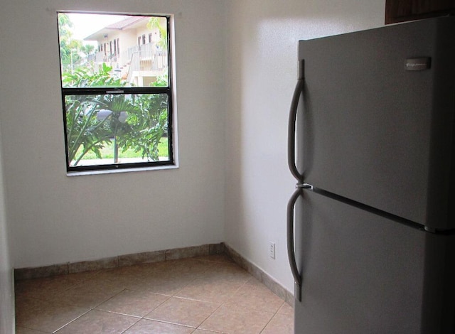 kitchen featuring stainless steel fridge and light tile patterned flooring