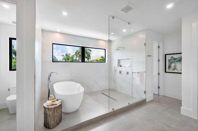 bathroom with tile walls, tile floors, a shower with shower door, and toilet