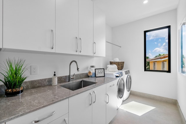 laundry room featuring separate washer and dryer, sink, and cabinets