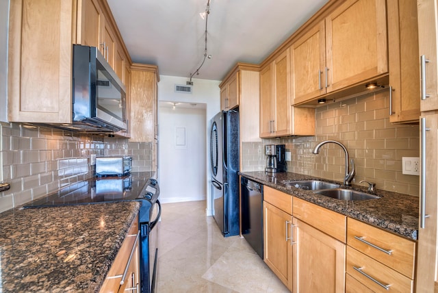 kitchen with decorative backsplash, track lighting, sink, black appliances, and dark stone countertops