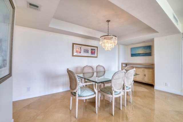 dining room featuring a notable chandelier and a raised ceiling