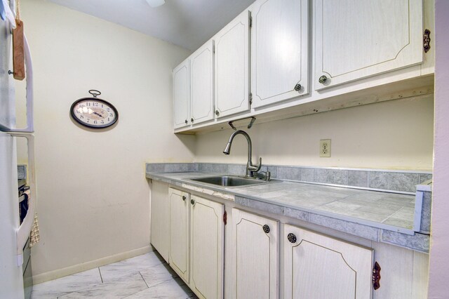 kitchen with sink, white fridge, and light tile floors