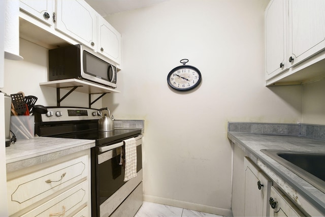 kitchen with stainless steel appliances, white cabinets, and light tile floors