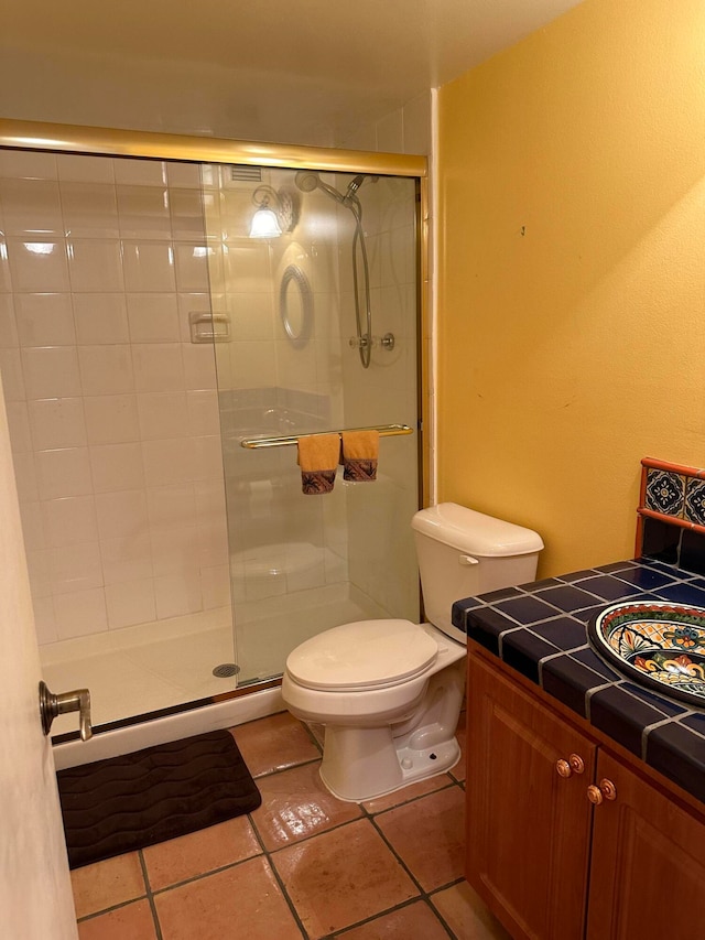 bathroom featuring walk in shower, tile flooring, vanity, and toilet