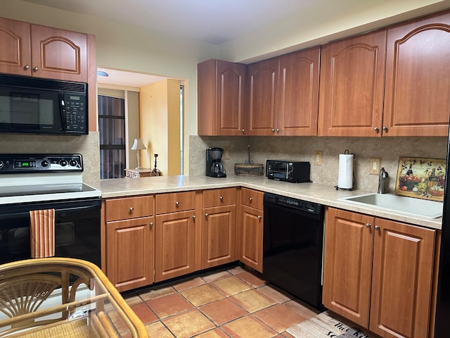 kitchen featuring sink, black appliances, tasteful backsplash, and light tile floors