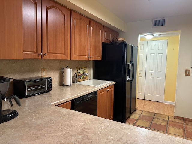 kitchen featuring sink, black appliances, and light tile floors