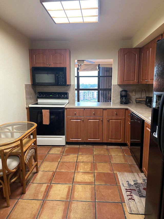 kitchen featuring backsplash, black appliances, and light tile floors