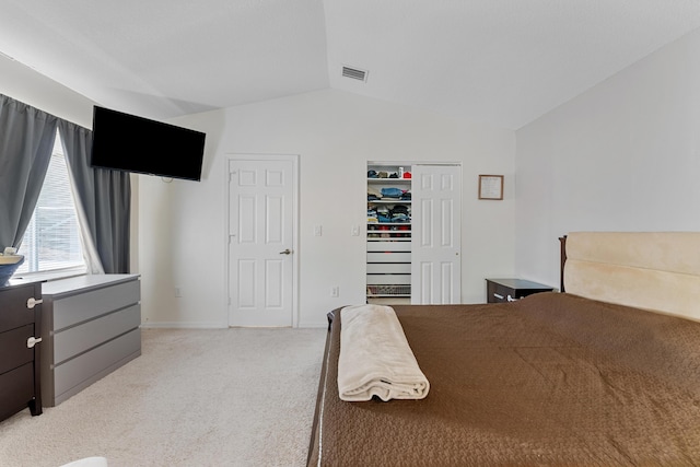 bedroom featuring light carpet, baseboards, visible vents, vaulted ceiling, and a closet