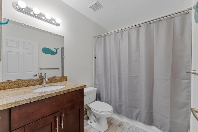 full bathroom with toilet, vanity, and visible vents