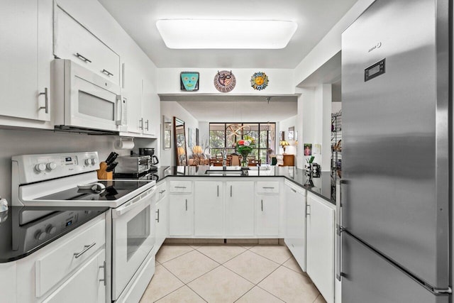 kitchen with sink, white cabinets, white appliances, and light tile floors