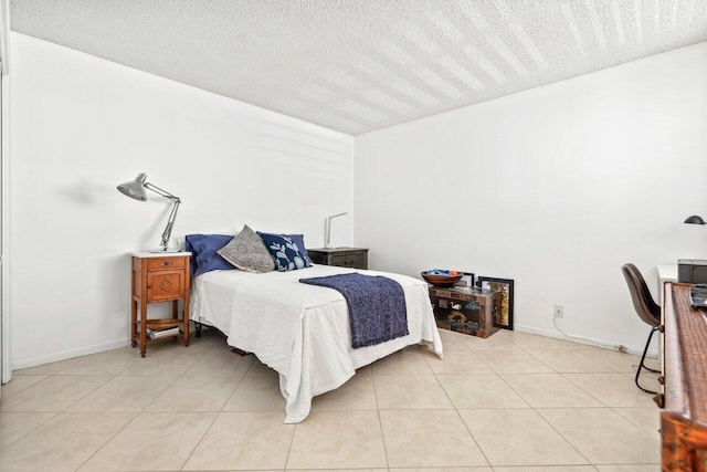 bedroom with tile flooring and a textured ceiling