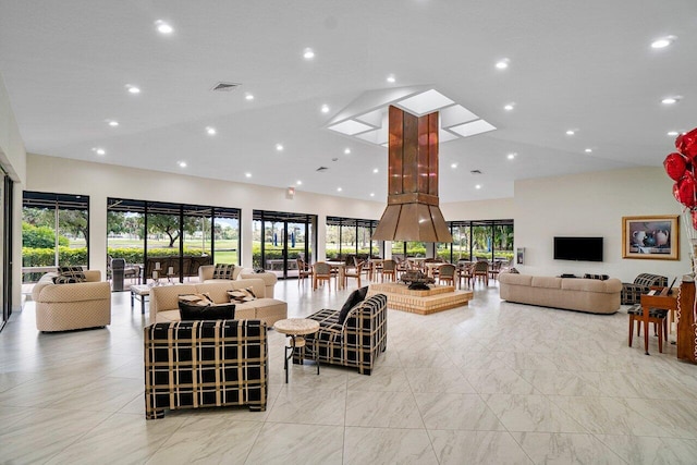 living room featuring plenty of natural light, a towering ceiling, and light tile floors