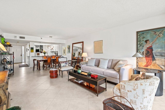 tiled living room featuring a textured ceiling