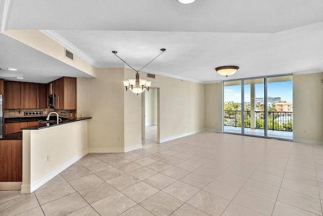 kitchen featuring a chandelier, light tile patterned floors, tasteful backsplash, and ornamental molding