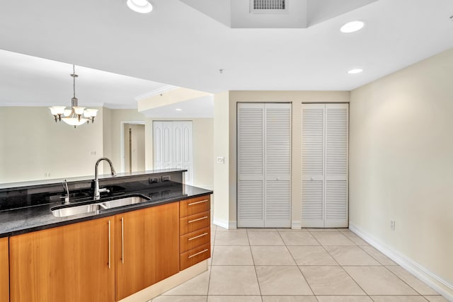 kitchen featuring sink, an inviting chandelier, pendant lighting, light tile patterned floors, and ornamental molding