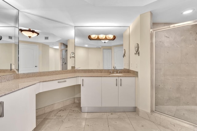 bathroom featuring vanity and a shower with shower door