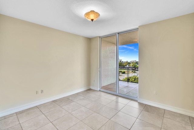 tiled spare room with floor to ceiling windows and a textured ceiling